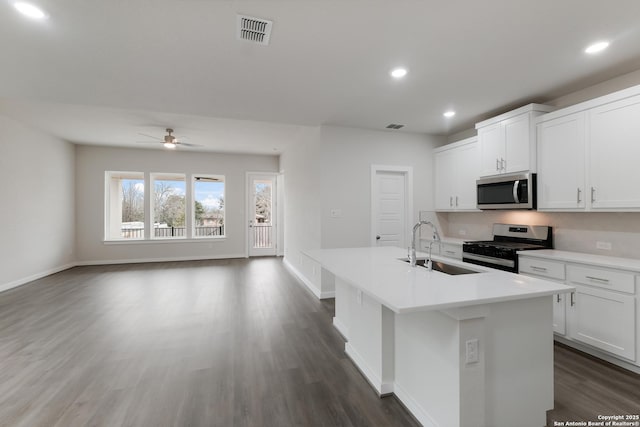 kitchen featuring stainless steel appliances, an island with sink, ceiling fan, white cabinets, and sink