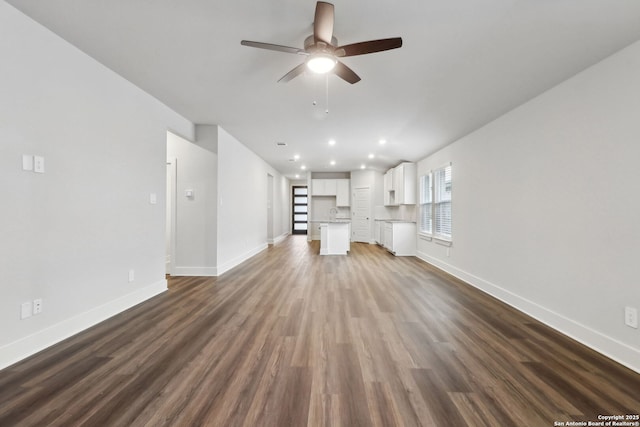 unfurnished living room with ceiling fan and dark hardwood / wood-style floors