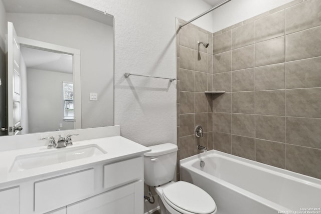 full bathroom with tiled shower / bath combo, vanity, and toilet