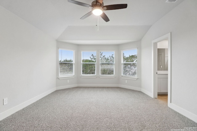 carpeted empty room featuring vaulted ceiling and ceiling fan