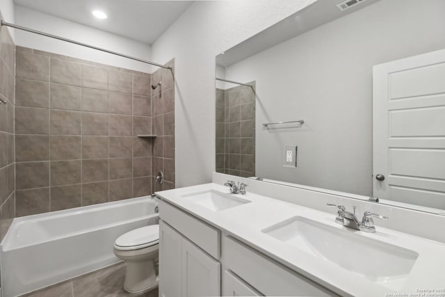 full bathroom with vanity, tiled shower / bath combo, and toilet