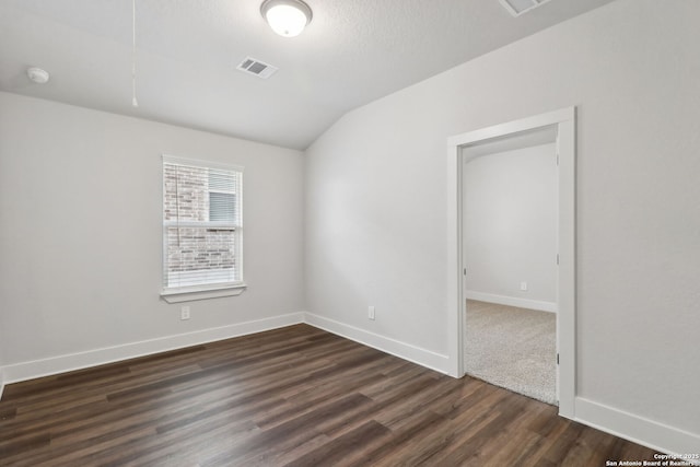 unfurnished room with vaulted ceiling and dark hardwood / wood-style floors