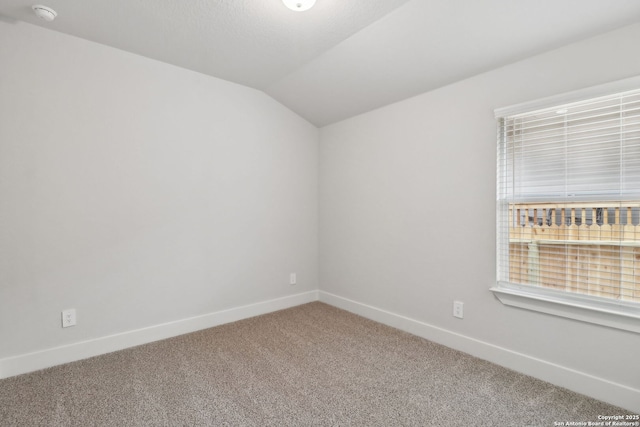 unfurnished room with lofted ceiling and carpet