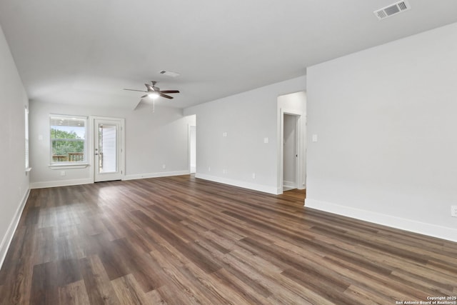 unfurnished living room featuring dark wood-type flooring and ceiling fan