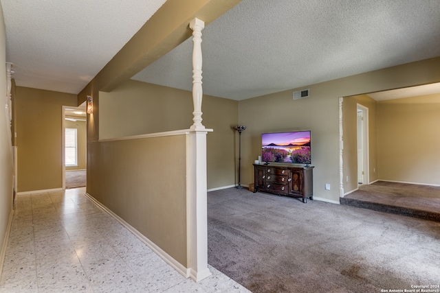 interior space with a textured ceiling and light colored carpet