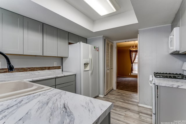 kitchen with white appliances, sink, light wood-type flooring, and gray cabinetry