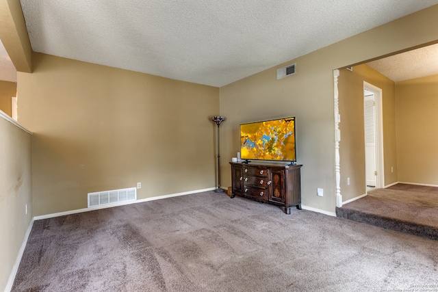 unfurnished living room with a textured ceiling and carpet flooring