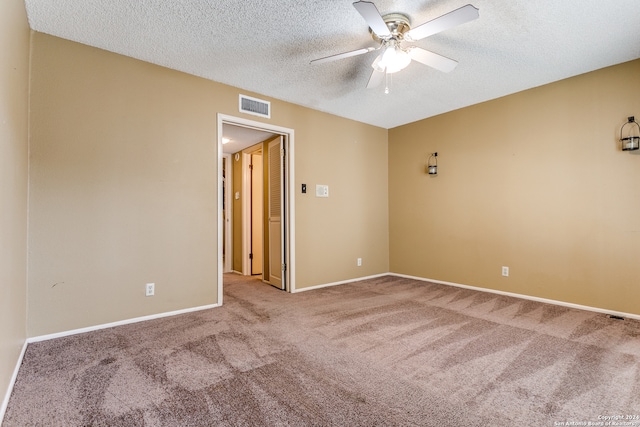 carpeted empty room featuring a textured ceiling and ceiling fan