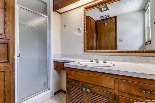 bathroom with vanity, tile patterned floors, a textured ceiling, and an enclosed shower