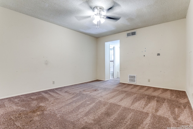 empty room with carpet floors and a textured ceiling