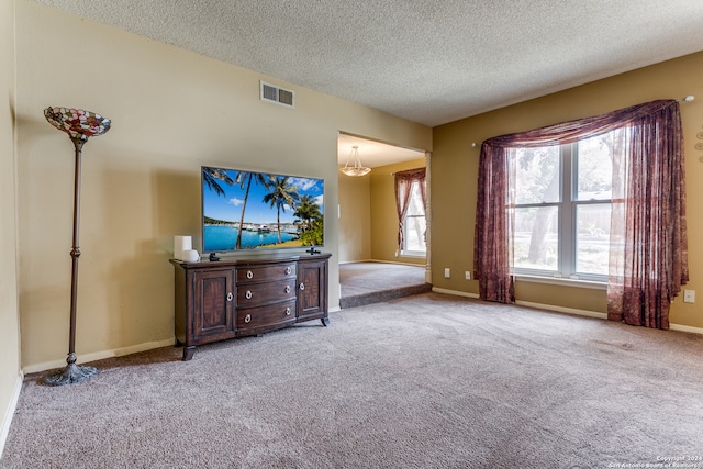 unfurnished living room with a textured ceiling, plenty of natural light, and light colored carpet