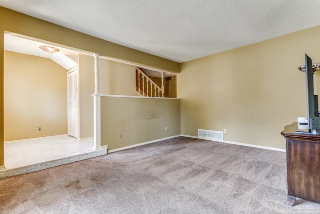 unfurnished living room featuring carpet and a textured ceiling