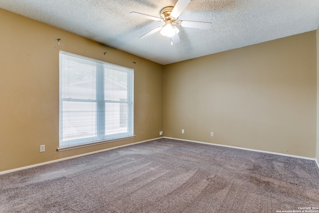 carpeted spare room with ceiling fan and a textured ceiling