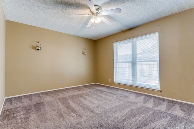 spare room with a textured ceiling, carpet floors, and ceiling fan