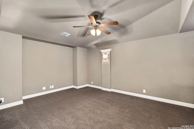 unfurnished room featuring a textured ceiling, dark carpet, and ceiling fan