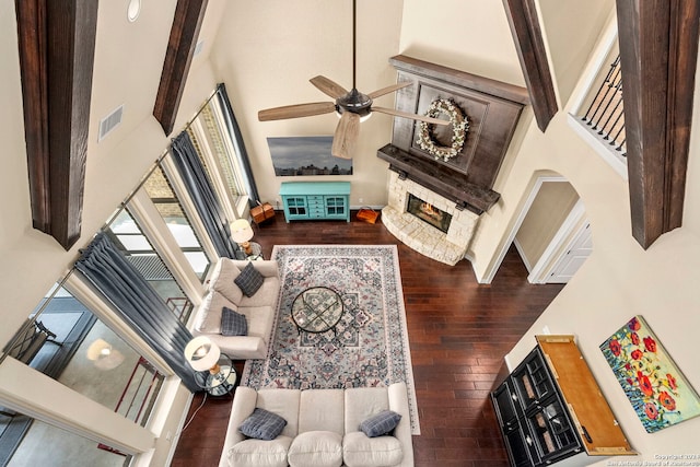 living room featuring a towering ceiling, beamed ceiling, and dark hardwood / wood-style floors