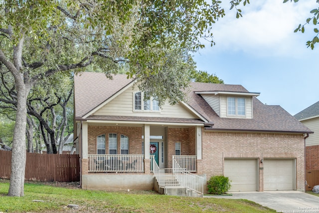 view of front facade featuring a front yard, a garage, and a porch