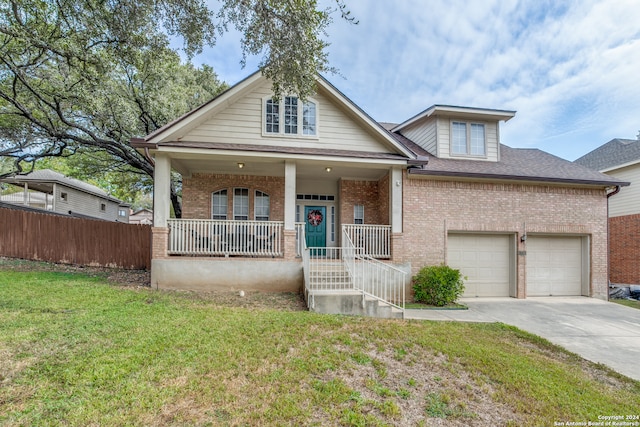 view of front of property with a front yard, a porch, and a garage