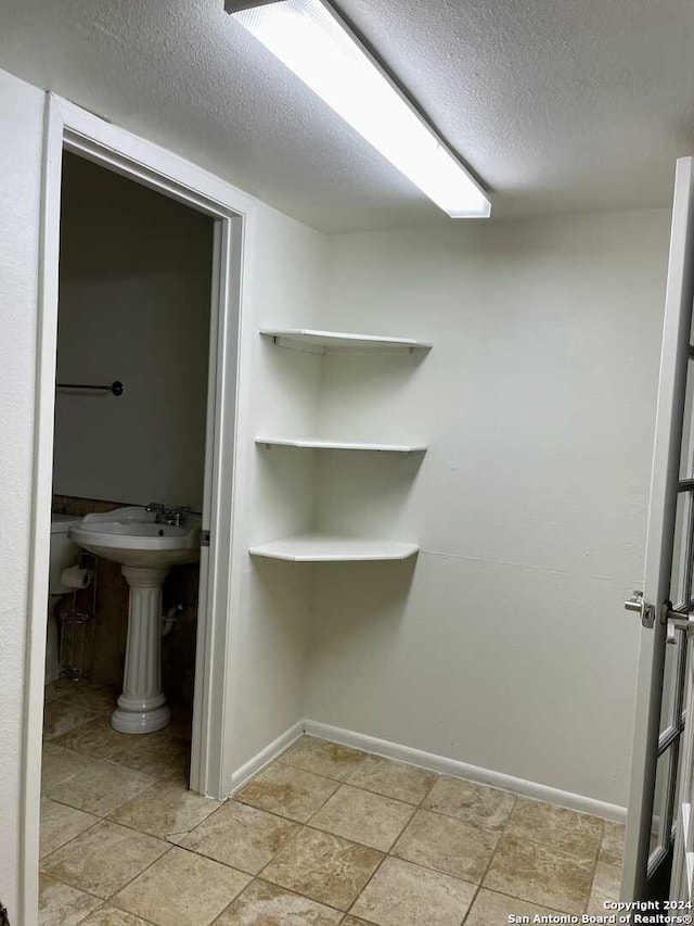 bathroom featuring tile patterned floors and a textured ceiling