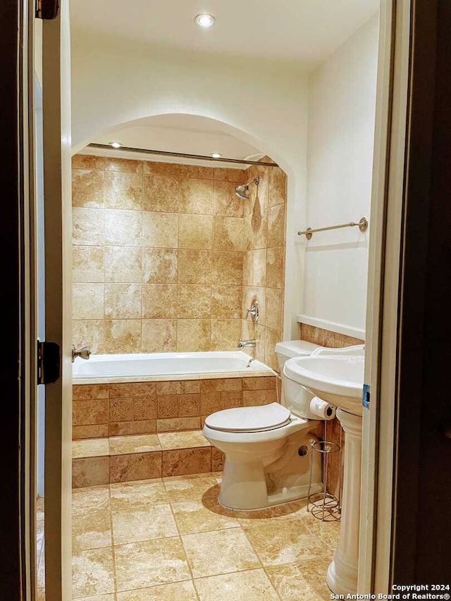 bathroom with tiled shower / bath and toilet