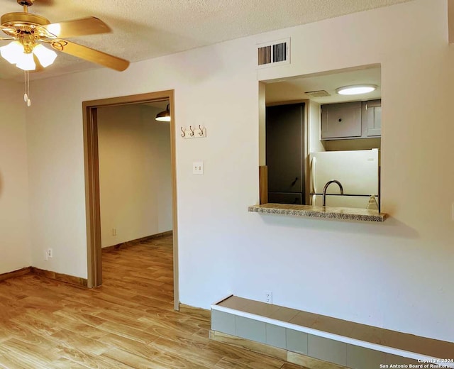 kitchen featuring a textured ceiling, white fridge, wood-type flooring, and ceiling fan