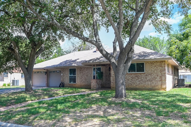 ranch-style house with a front yard, a garage, and central air condition unit