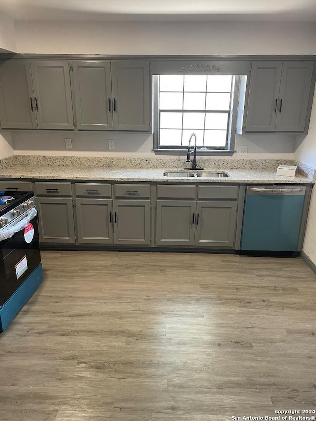 kitchen featuring dishwasher, sink, black range with gas cooktop, and light wood-type flooring