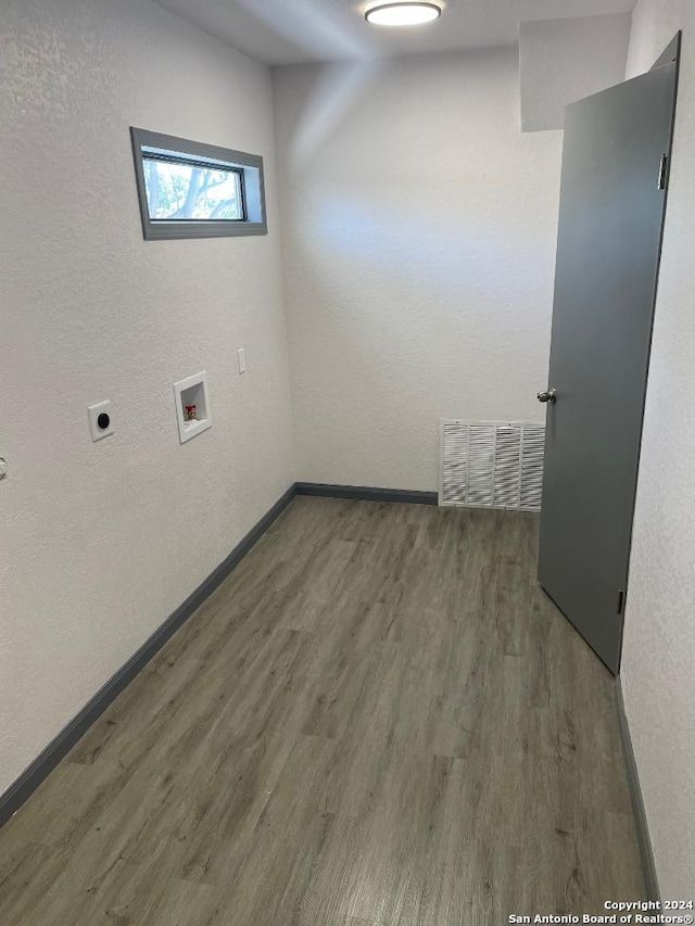 washroom with dark wood-type flooring, washer hookup, and hookup for an electric dryer