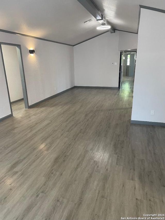 empty room with lofted ceiling and dark wood-type flooring