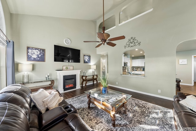 living room featuring high vaulted ceiling, dark wood-type flooring, sink, and ceiling fan