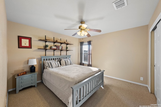 bedroom with a closet, ceiling fan, and light carpet