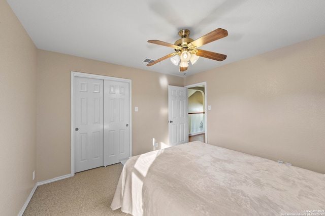 bedroom featuring a closet, light colored carpet, and ceiling fan