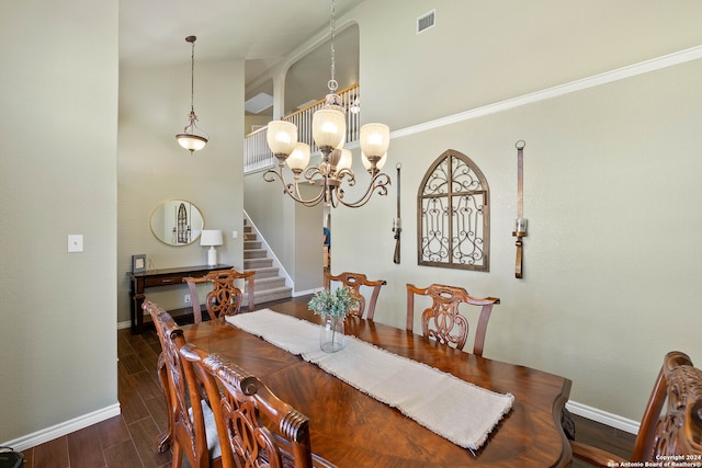 dining space with a notable chandelier, dark hardwood / wood-style floors, vaulted ceiling, and crown molding