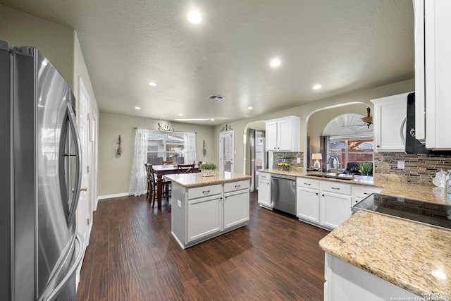 kitchen with a kitchen island, white cabinets, dark wood-type flooring, and stainless steel appliances