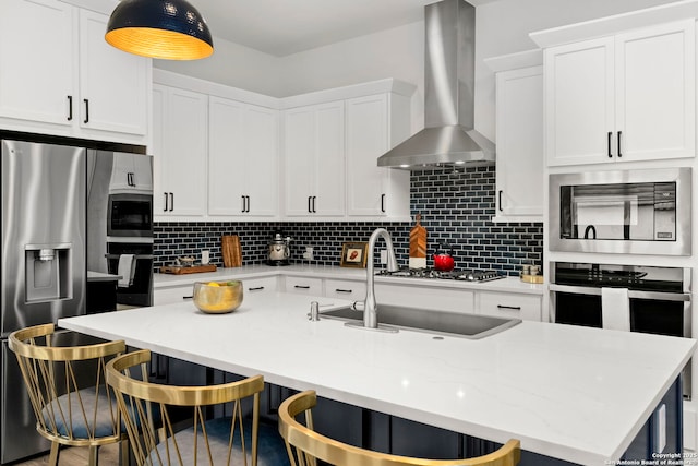 kitchen with built in microwave, a breakfast bar, white cabinets, and wall chimney exhaust hood