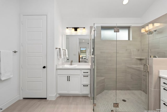 bathroom featuring walk in shower and vanity