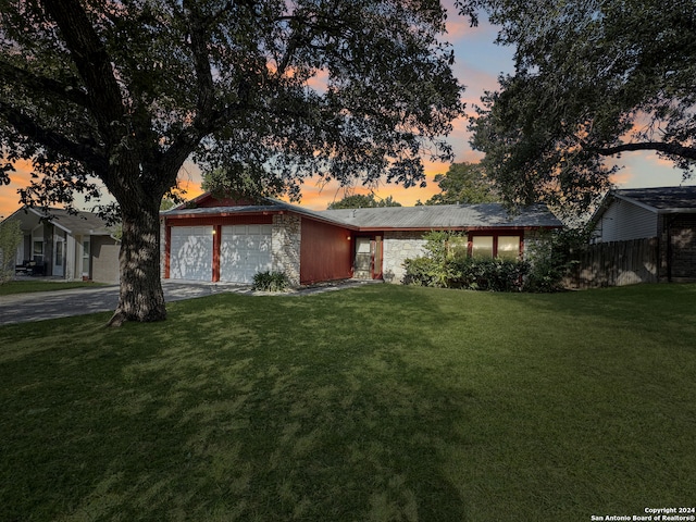 ranch-style house with a yard and a garage