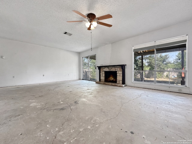 unfurnished living room with a textured ceiling, a fireplace, and ceiling fan