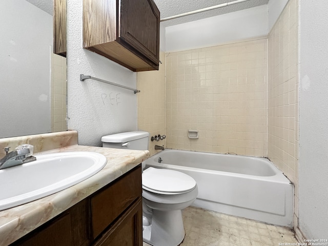 full bathroom featuring vanity, toilet, tiled shower / bath combo, and a textured ceiling