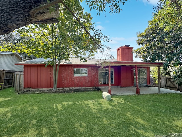 rear view of house with a yard and a patio