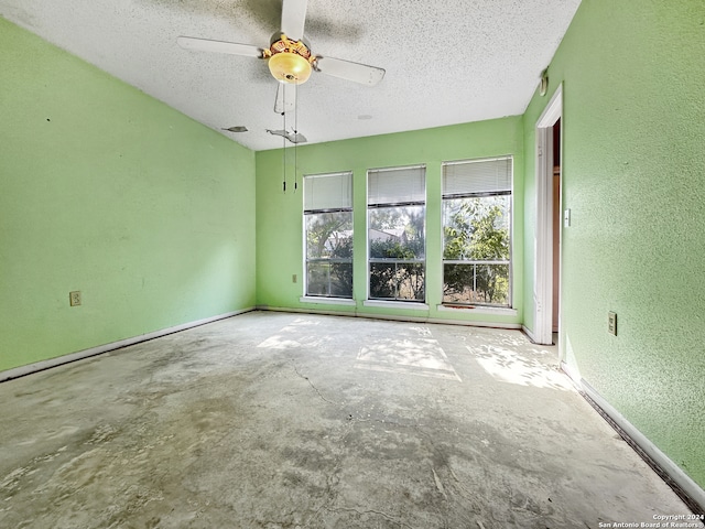 empty room featuring a textured ceiling, concrete flooring, and ceiling fan