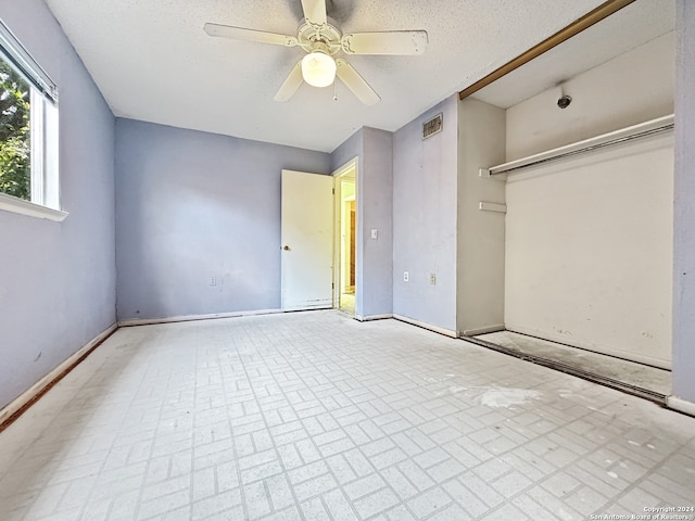 unfurnished bedroom with ceiling fan and a textured ceiling