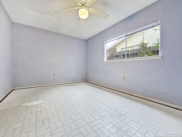 empty room with a textured ceiling and ceiling fan