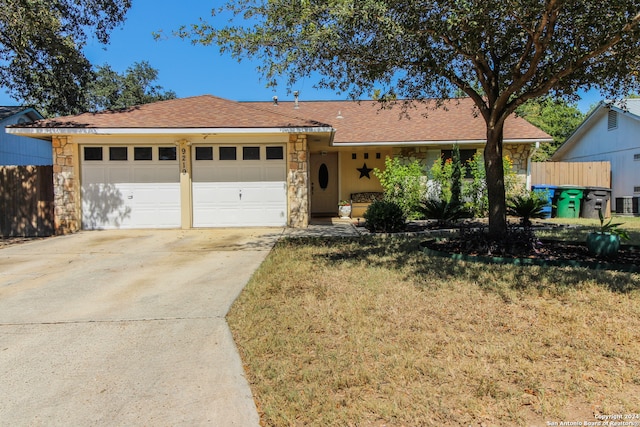 ranch-style home featuring a garage and a front lawn