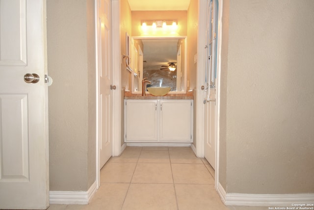 corridor with sink and light tile patterned floors