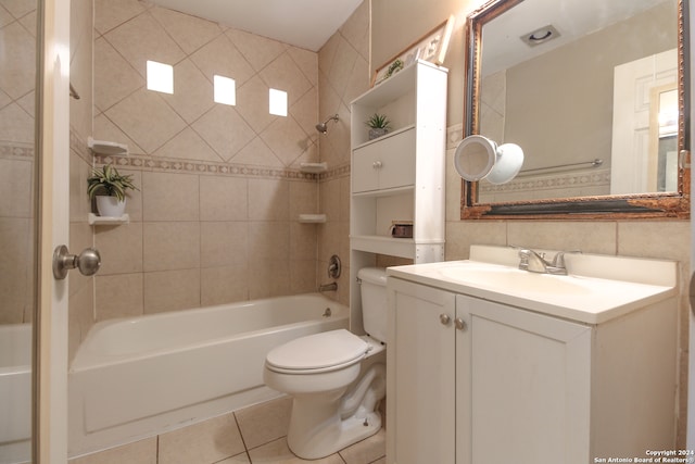 full bathroom featuring tiled shower / bath, tile walls, toilet, vanity, and tile patterned flooring