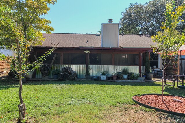 rear view of property with a lawn