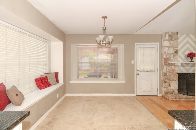 mudroom featuring light hardwood / wood-style floors, a chandelier, and a fireplace