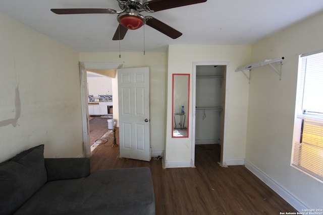 unfurnished bedroom with a spacious closet, dark wood-type flooring, and ceiling fan