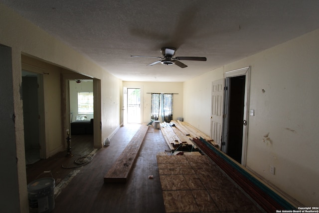 misc room featuring a textured ceiling, ceiling fan, and dark hardwood / wood-style flooring